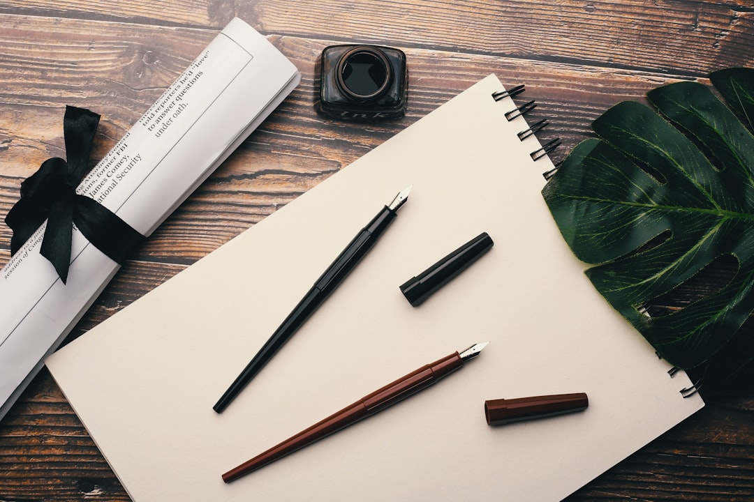 Fountain pens and notebook on wooden desk