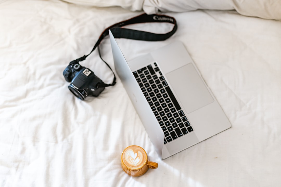 Laptop, camera, and coffee on bed