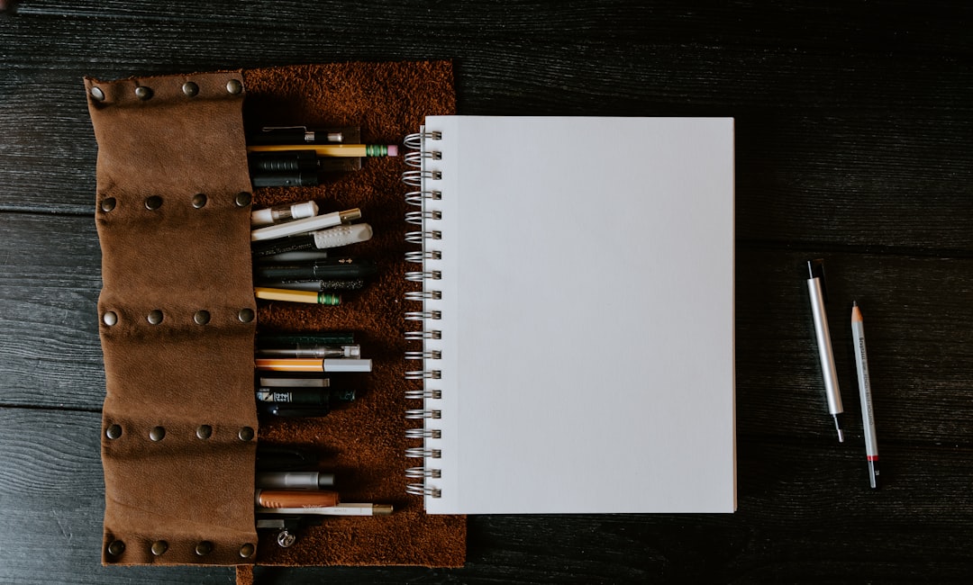 Open notebook and pens on dark table