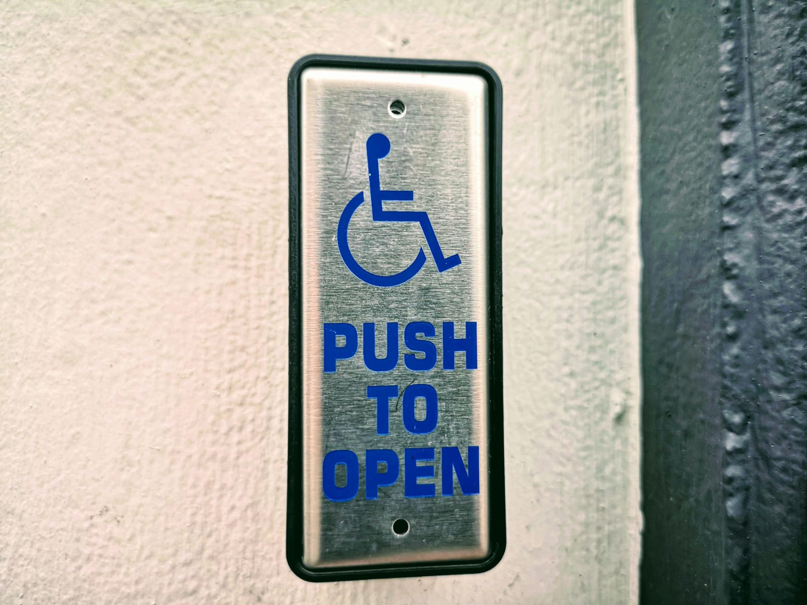 Accessible door button with wheelchair symbol