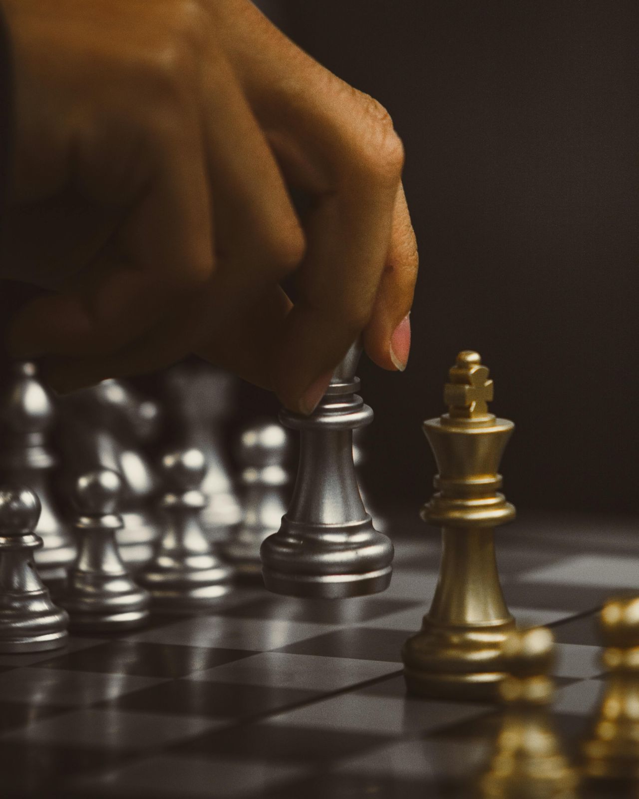 Hand moving chess piece on board