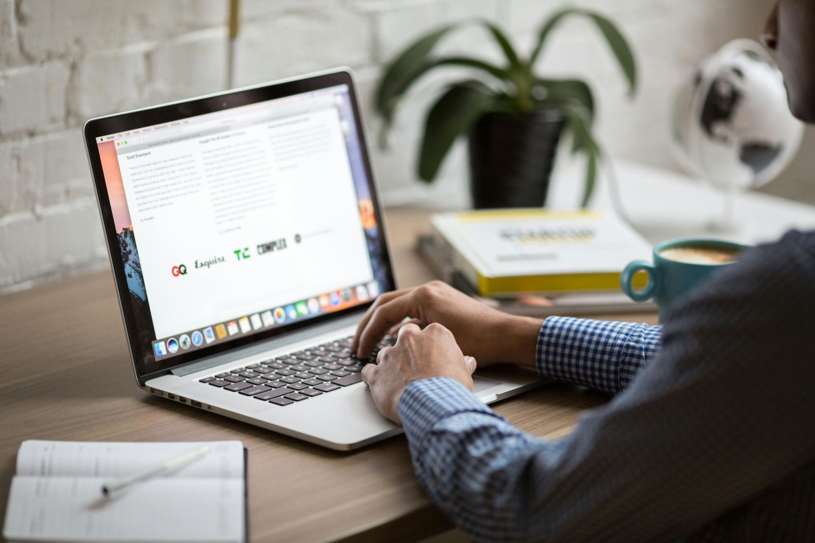 Person typing on laptop at desk workspace