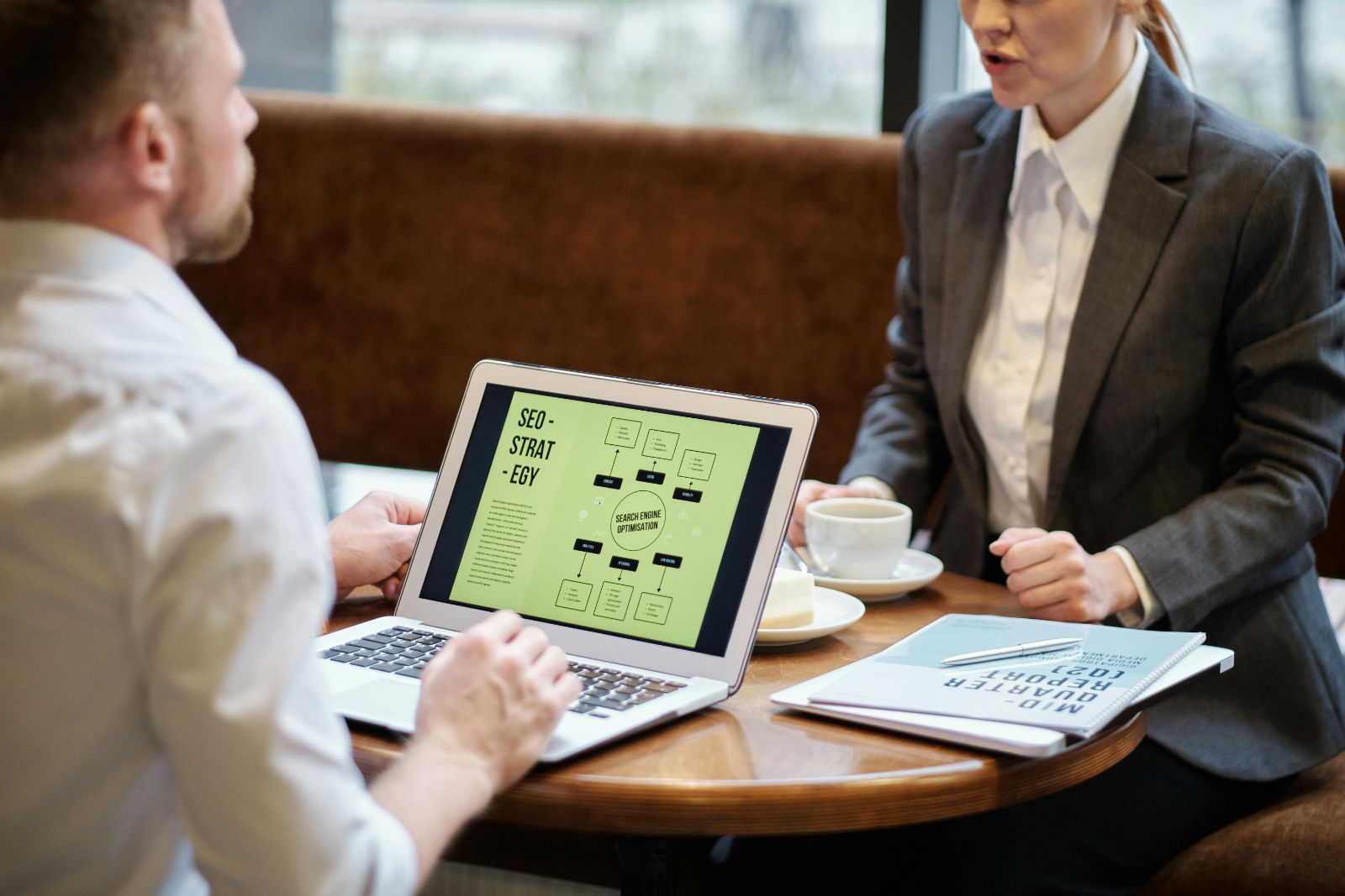 Business meeting discussing SEO strategy laptop