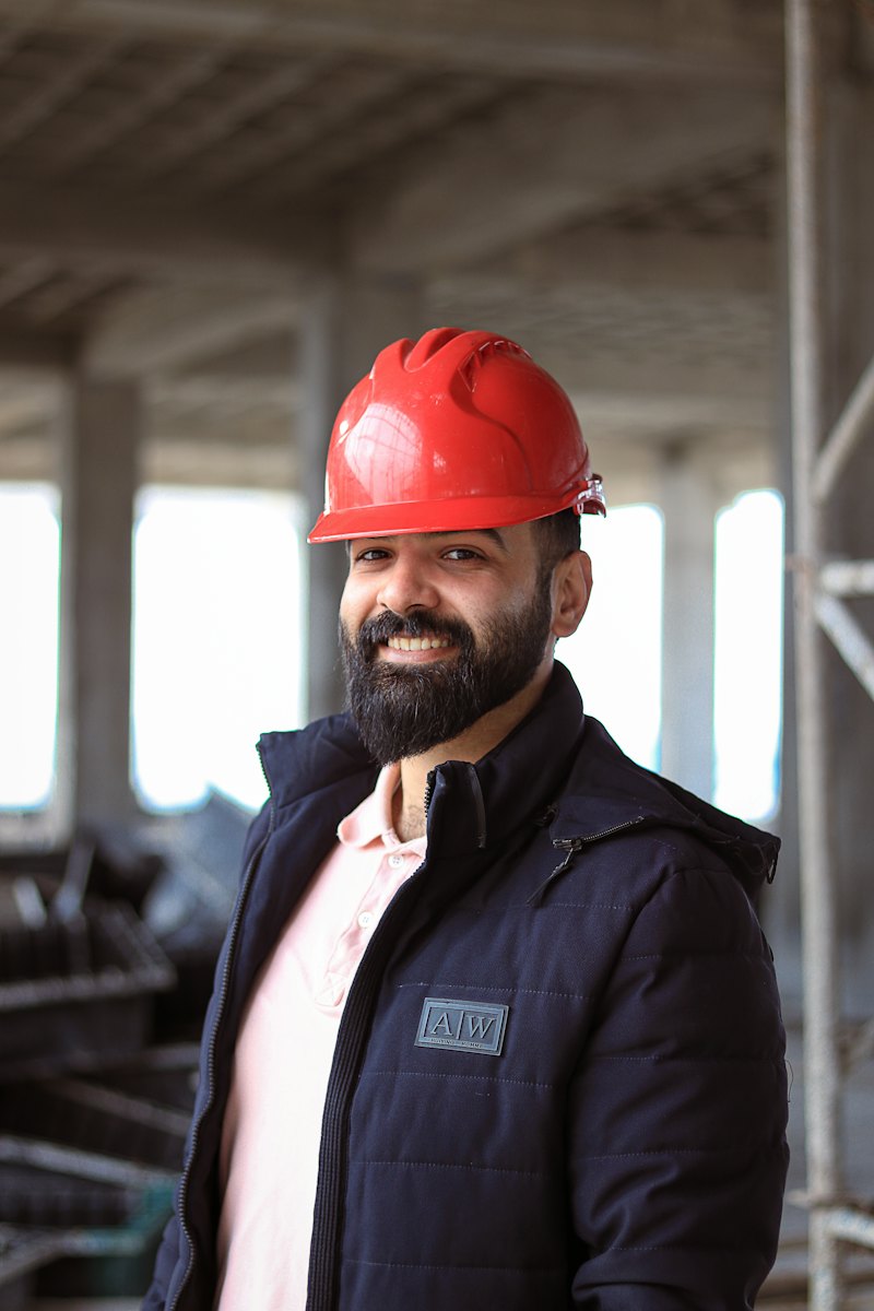 Construction company owner in a red hard hat on a job site